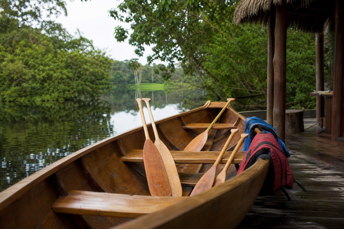A canoe with a child-sized paddle at a jungle lodge dock